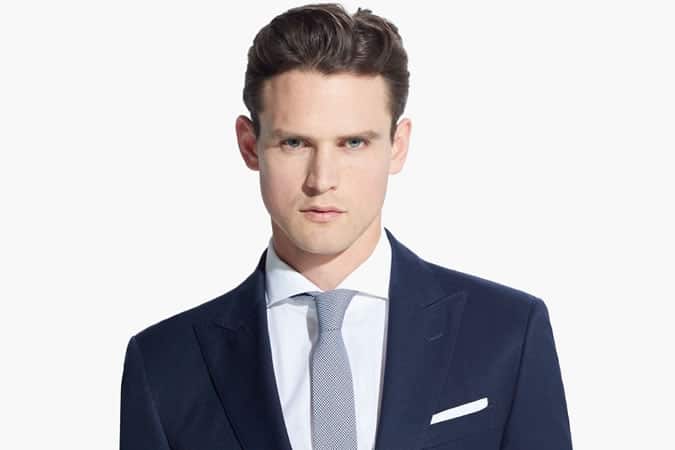 A white shirt and navy blazer contrasts well against sallow skin