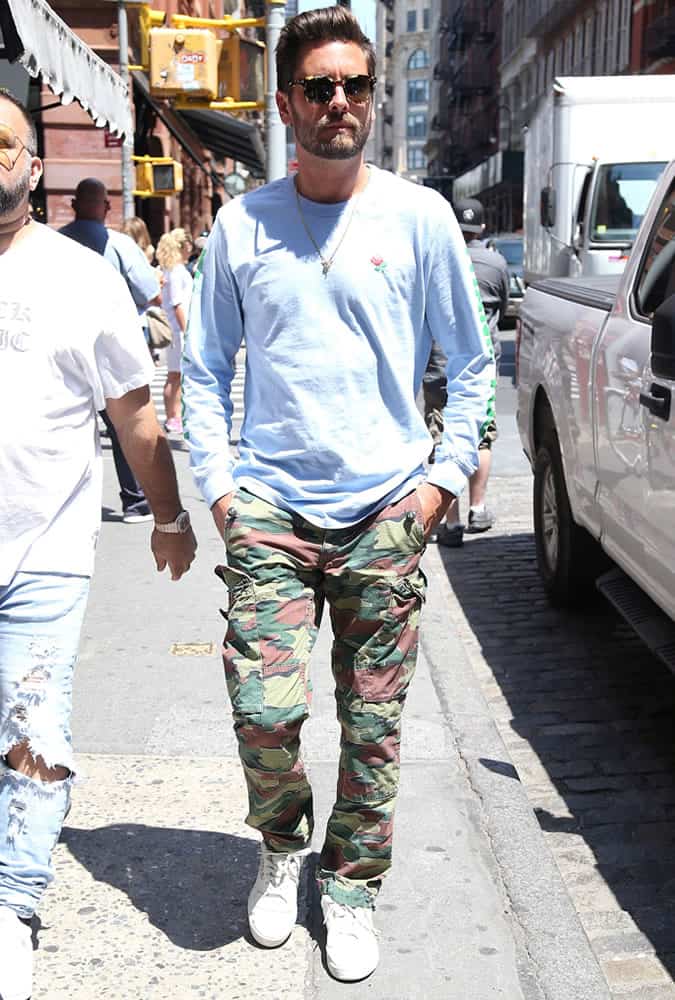 Scott Disick wearing camo trousers and a blue top