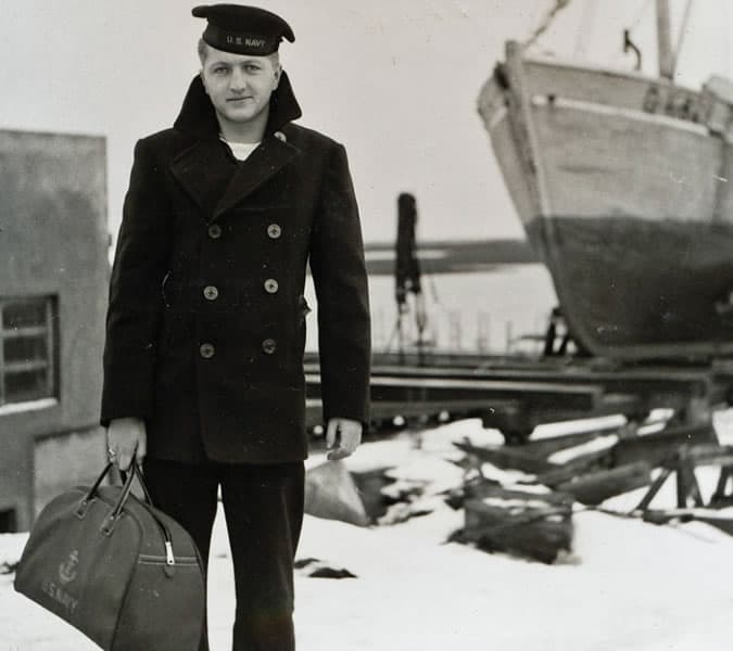 Old sailor wearing a peacoat and carrying a bag