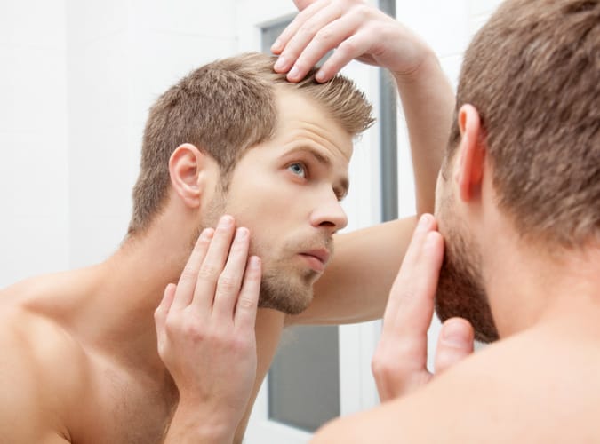 Man Checking His Hairline In The Mirror
