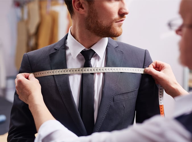 Man Being Measured By A Tailor