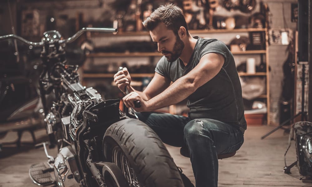 man fixing motorbike
