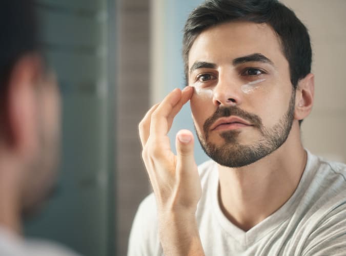 man applying eye cream