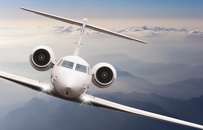 Airplane fly over clouds and Alps mountain on sunset. Front view of a big passenger or cargo aircraft, business jet, airline. Transportation, travel concept