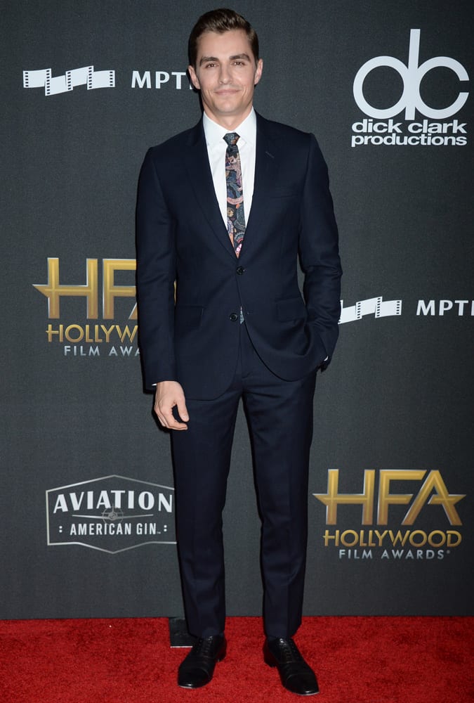 Dave Franco wearing a navy suit and printed tie