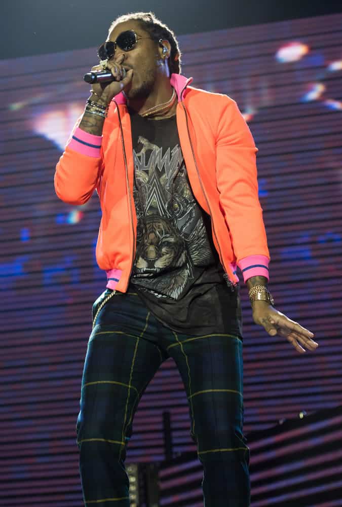 Future on stage wearing check trousers and an orange jacket