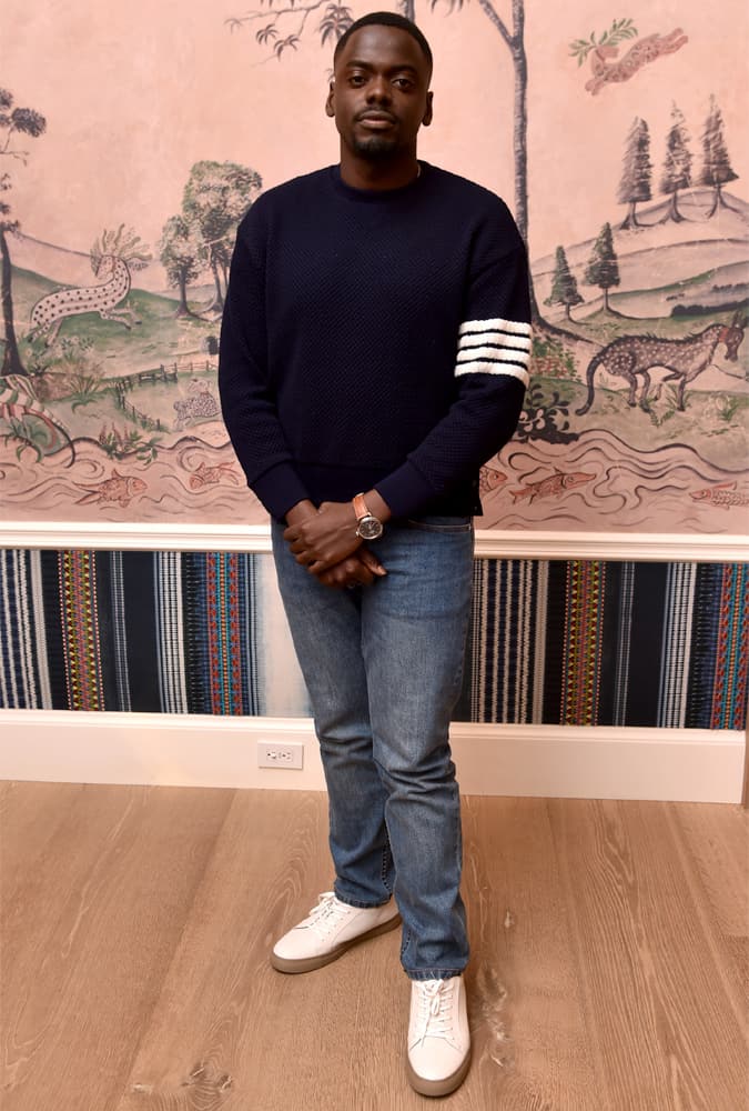 Daniel Kaluuya wearing a navy sweater with white racing stripes