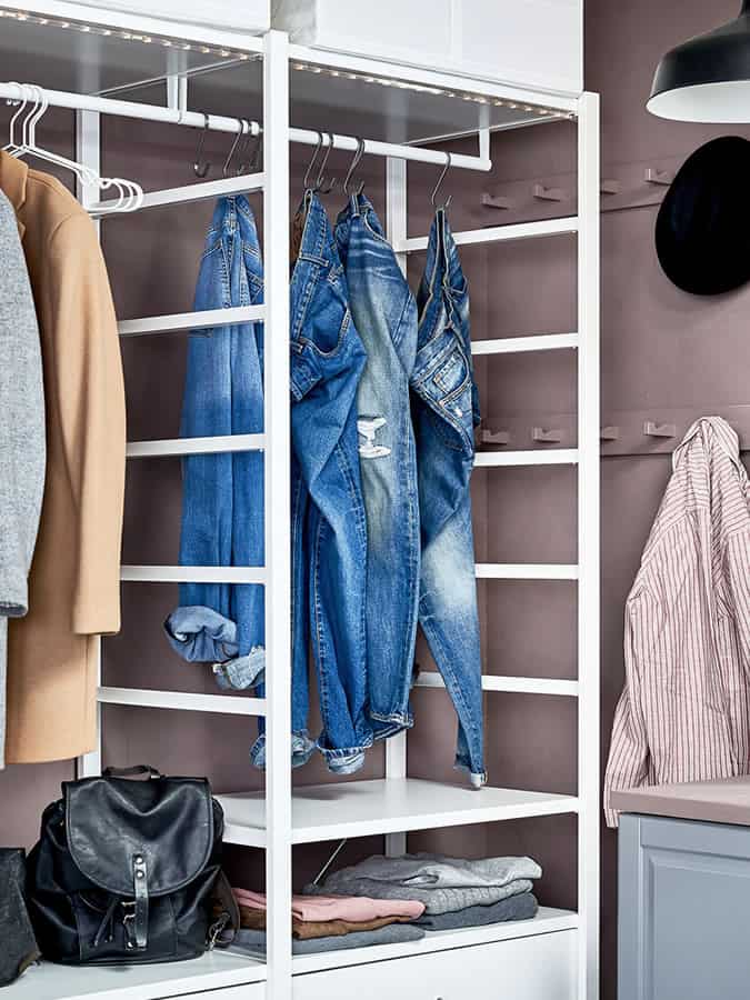 Denim jeans hanging in a closet/wardrobe using s hooks