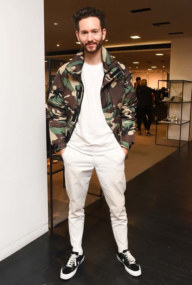 Isaac Hinin-Miller dressed in a white outfit with a camouflage jacket