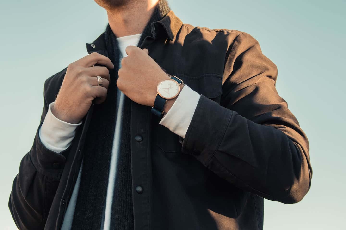 man adjusting his collar with chic watch on wrist