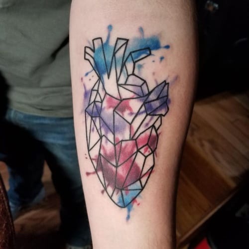 Geometric and watercolor tattoos on the forearm