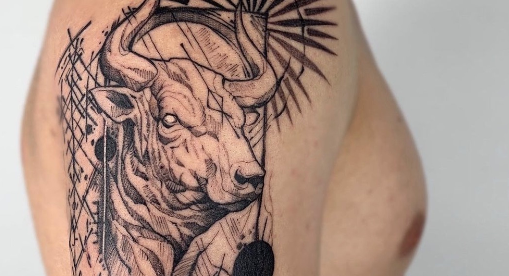 Micro-realistic charging bull tattoo on the inner arm