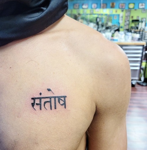 Tatouage sanskrit sur la poitrine
