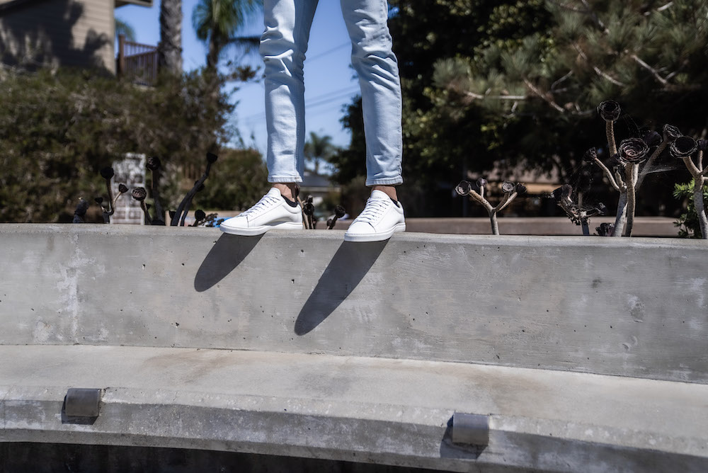 man standing on the back of a concrete bench highlighting Oliver Cabell Low 1s
