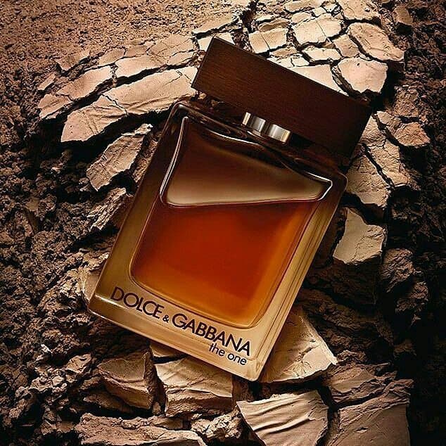 A bottle of Dolce & Gabanna The One with dried-up clay on the background