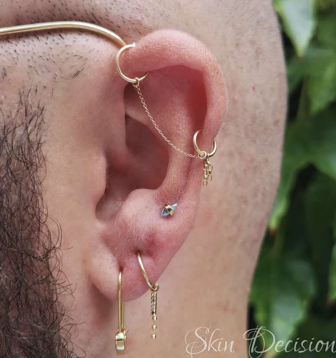 close up of an ear with lots of piercings