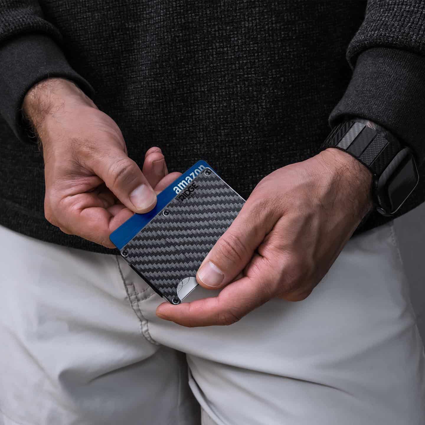 pulling out a card from a carbon fiber wallet