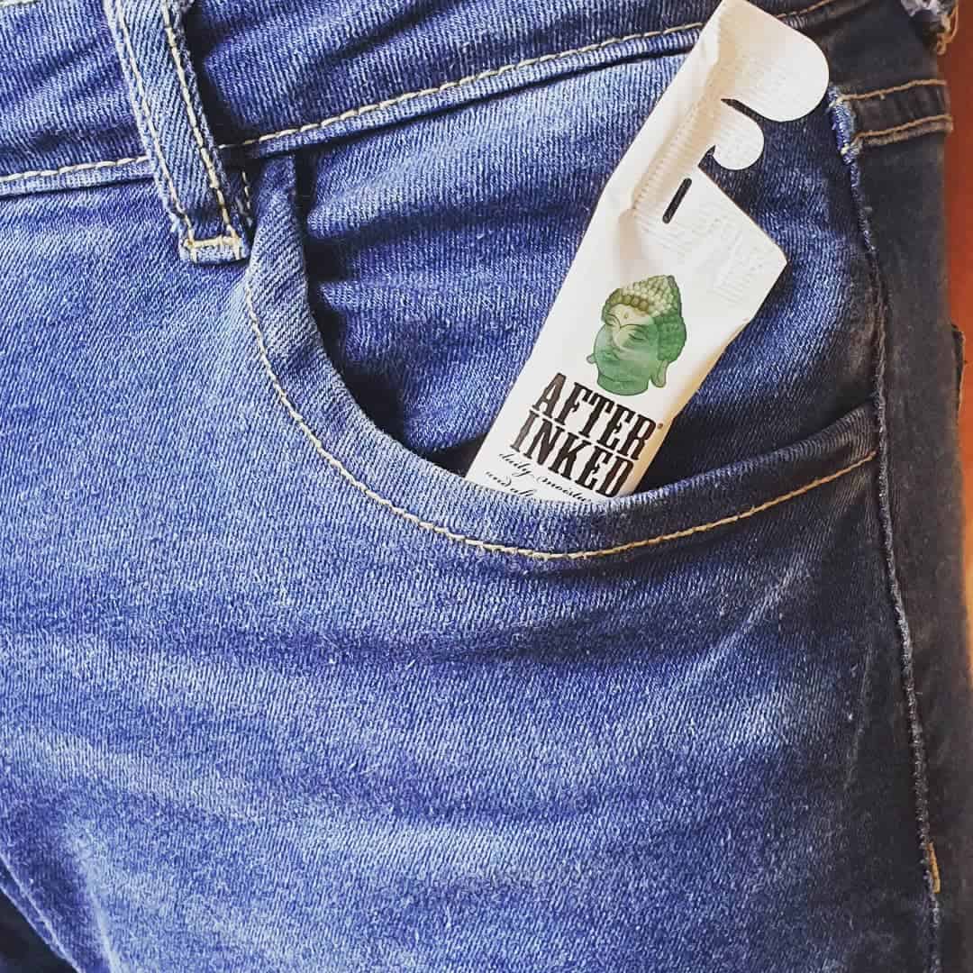 a travel size after inked daily moisturizer inside a jeans pocket