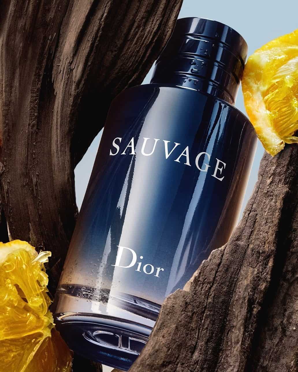 a bottle of Dior Sauvage in between wood and citrus slices