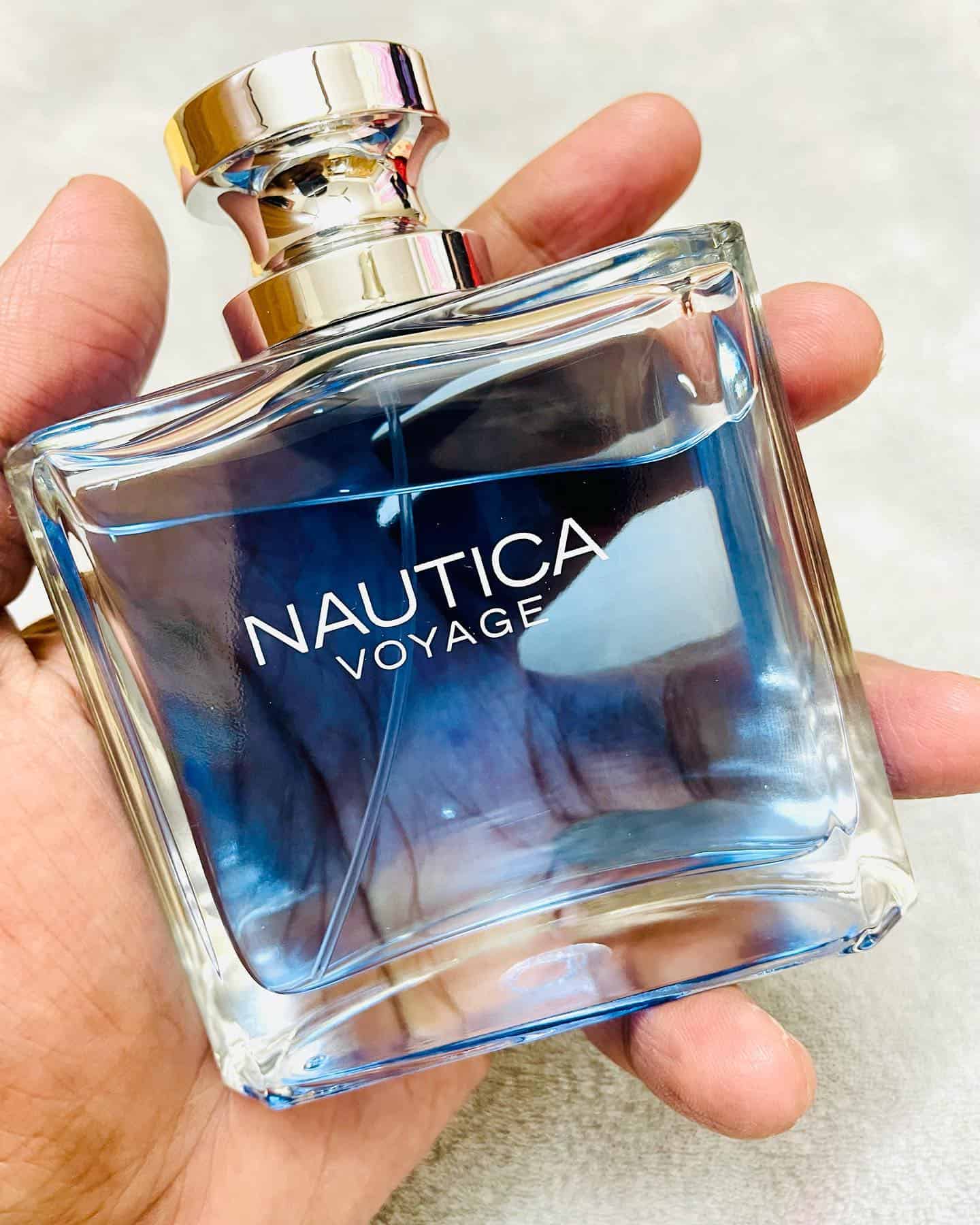 holding a bottle of nautica voyage