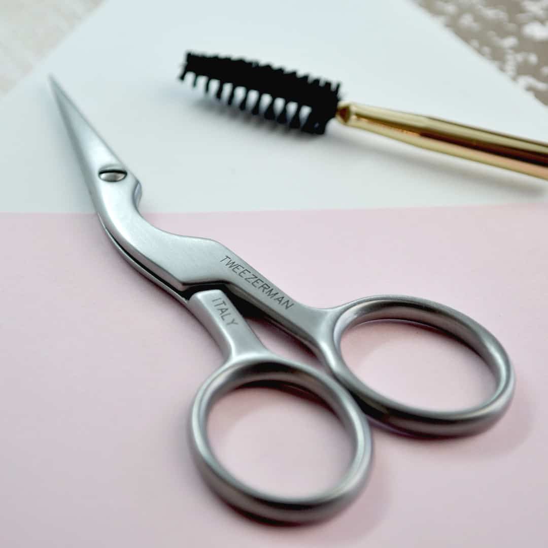 an eyebrow scissor and a brush