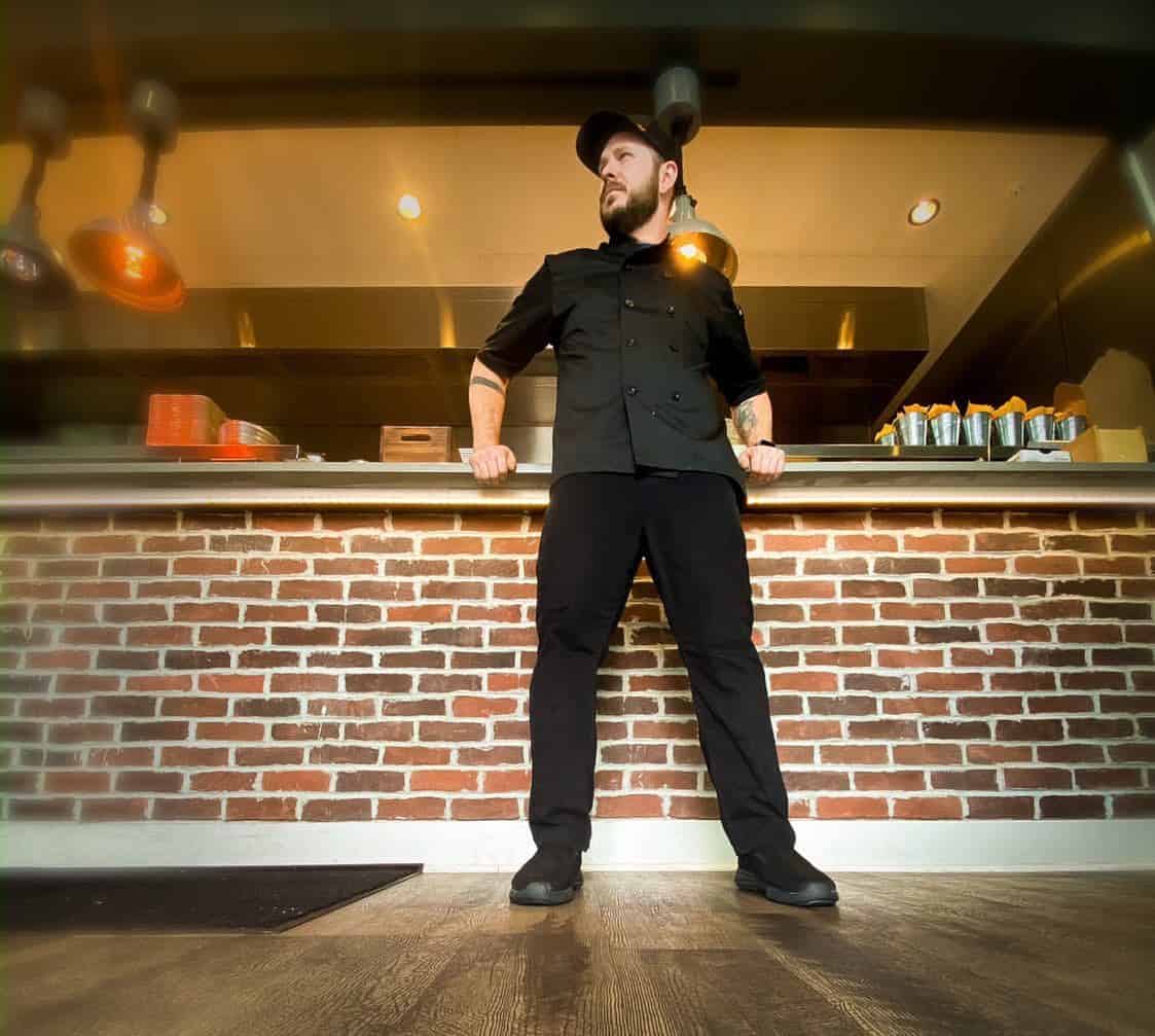 a chef leaning against the counter