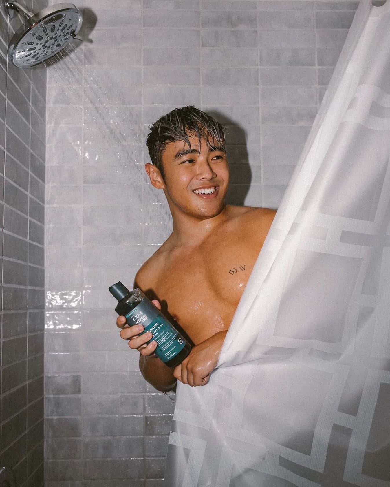 man holding a bottle of dove care men body wash