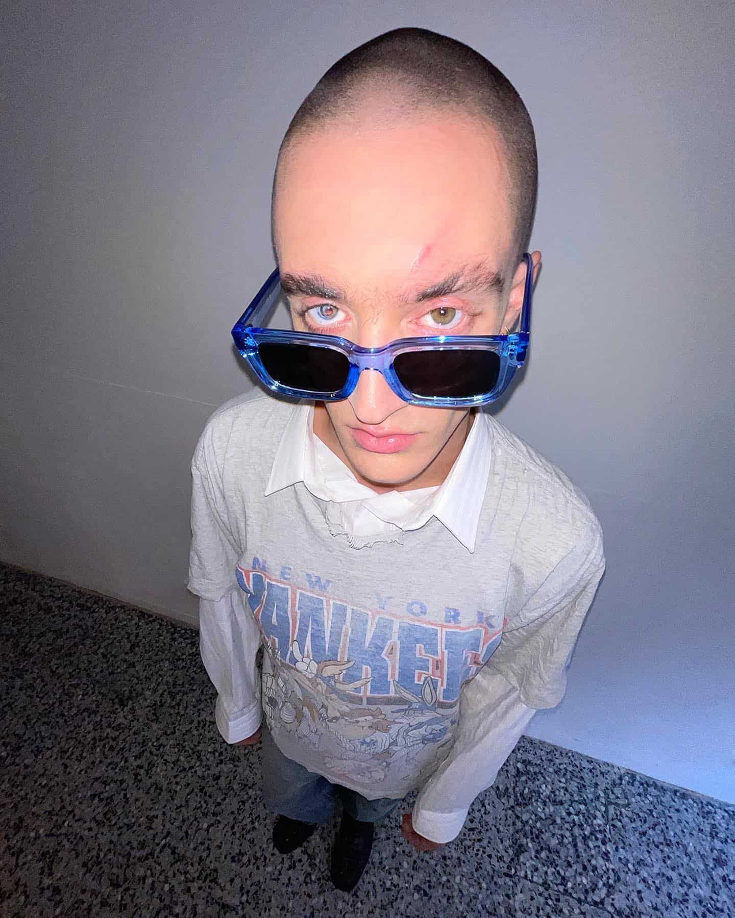 man in an oversized t-shirt wearing a blue sunglasses