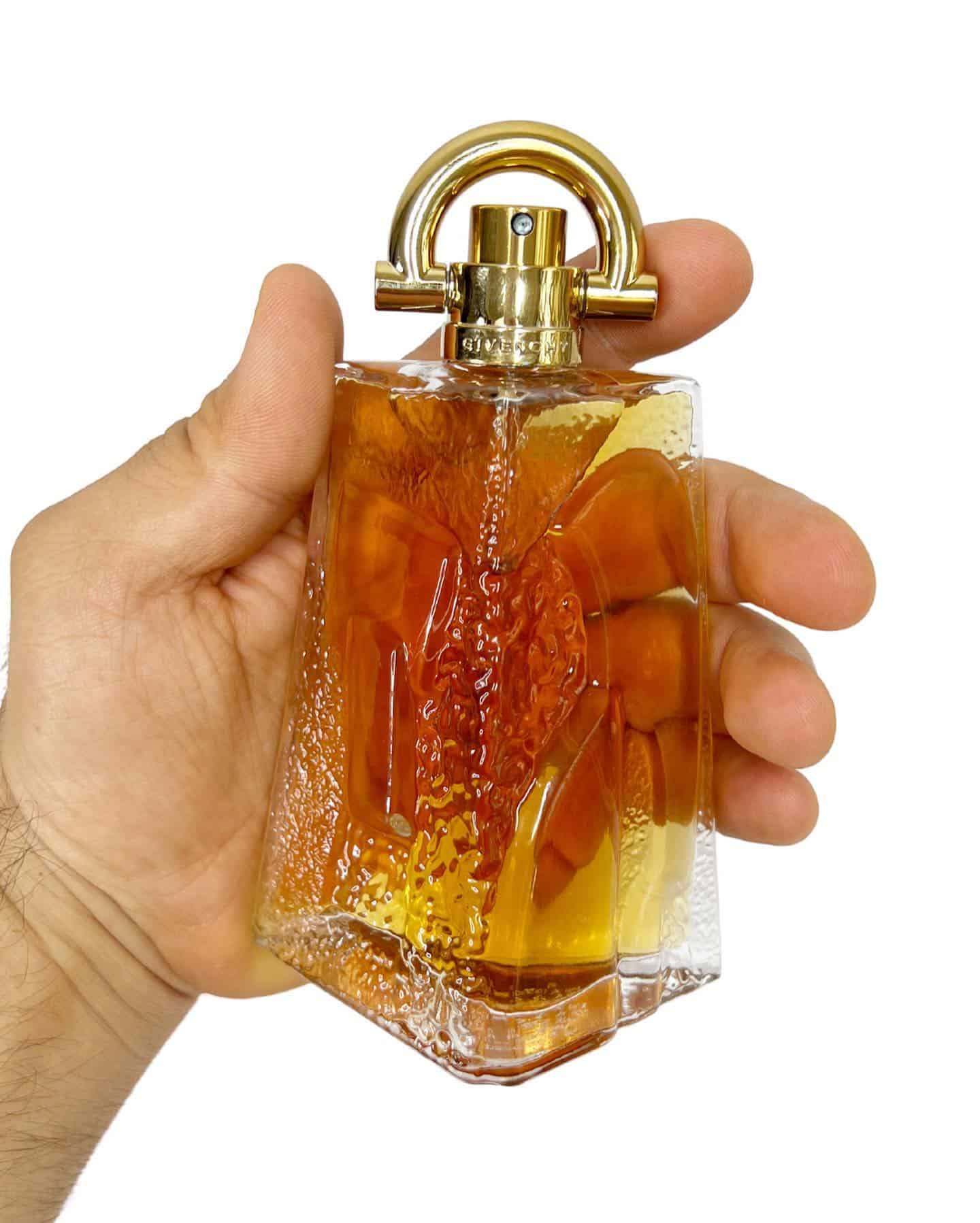 holding a bottle of givenchy Pi cologne