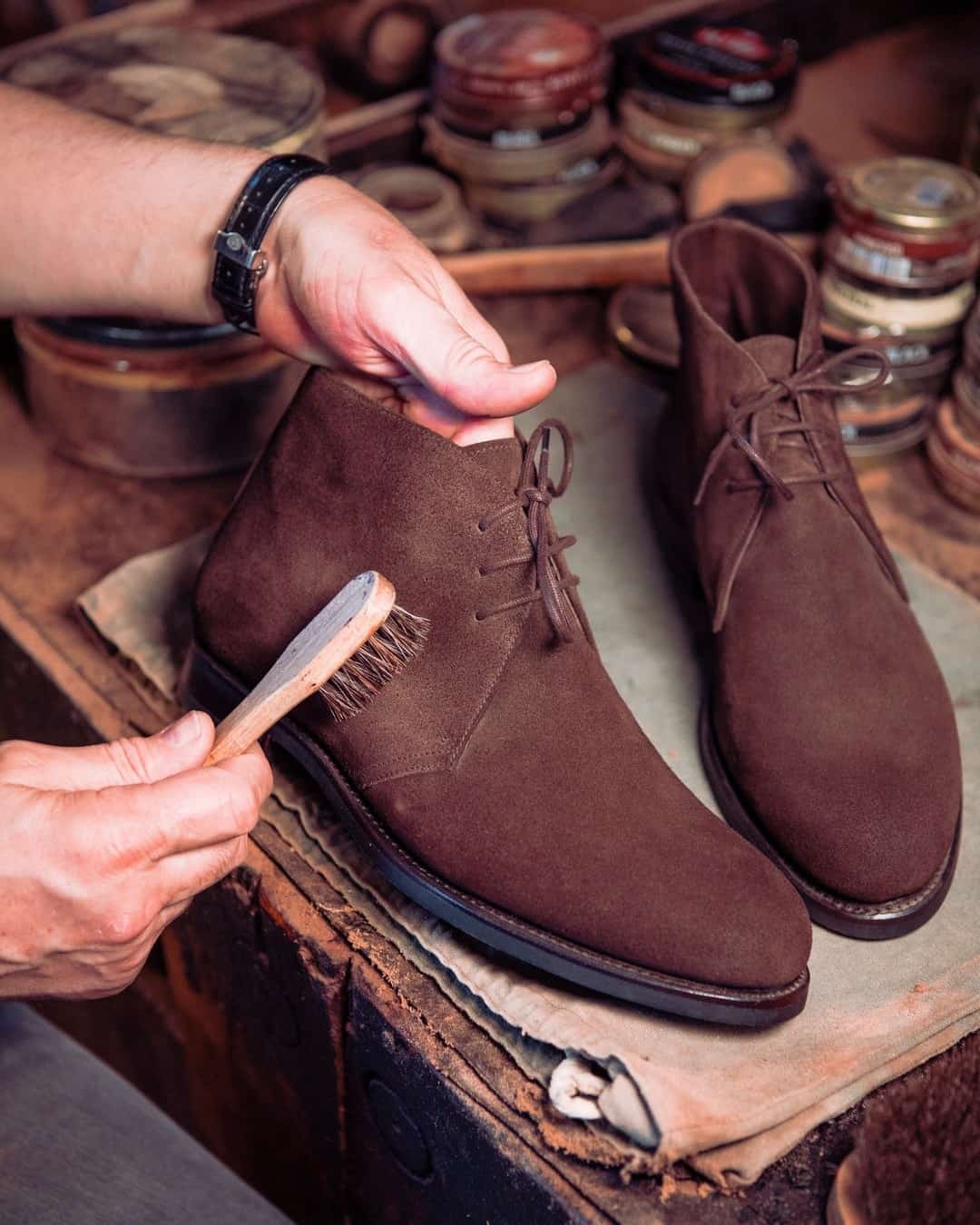 cleaning a pair of suede boots with a brush