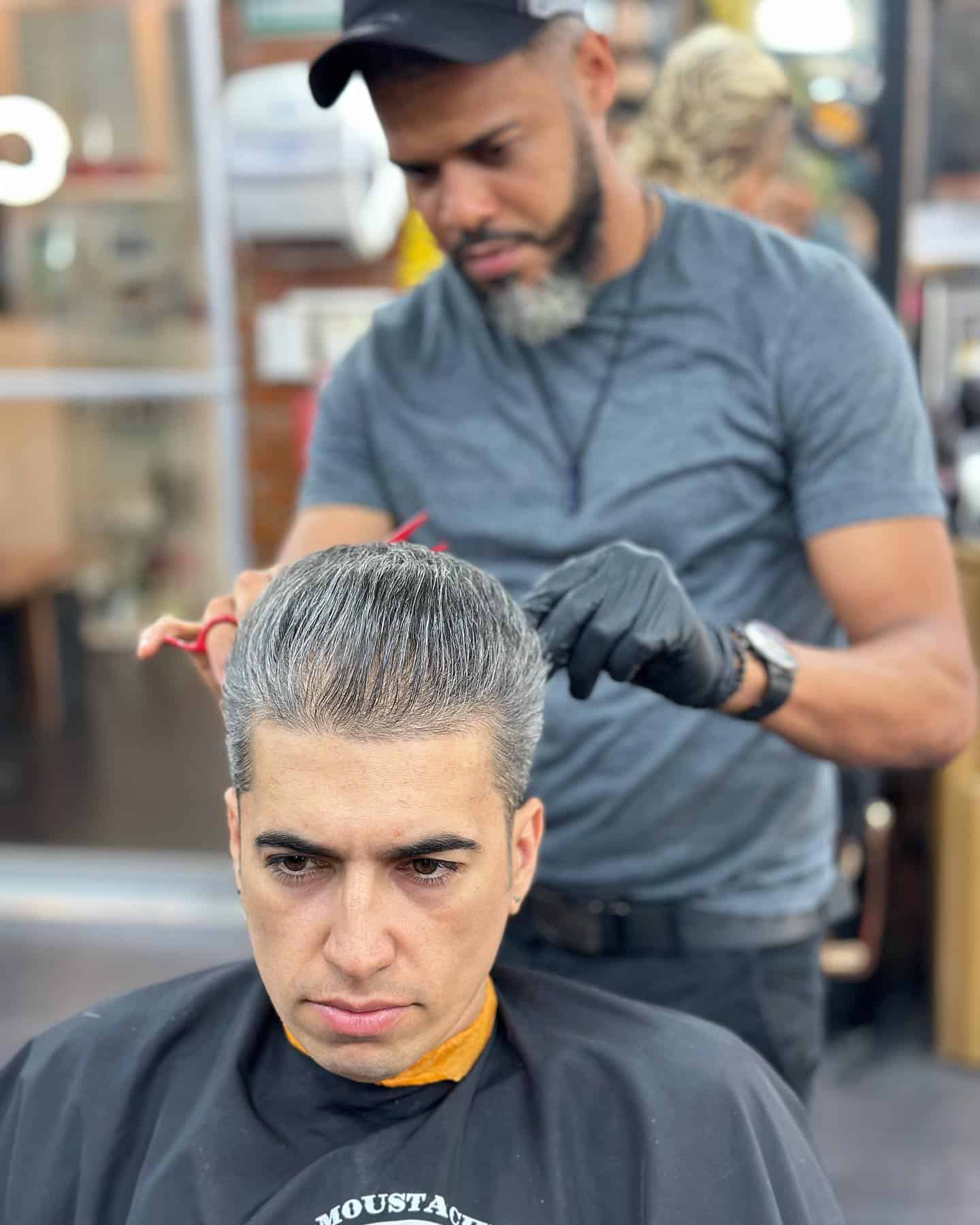 barber trimming a mans hair