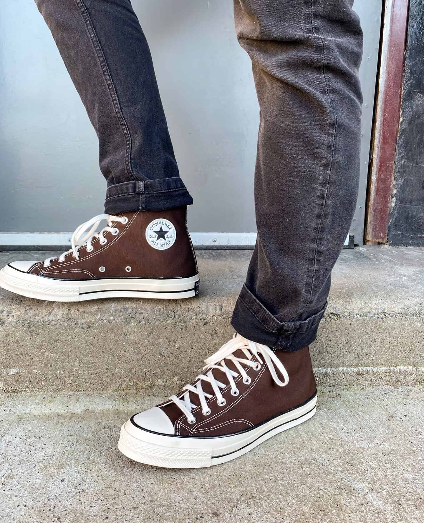 wearing a pair of brown hi tops by converse