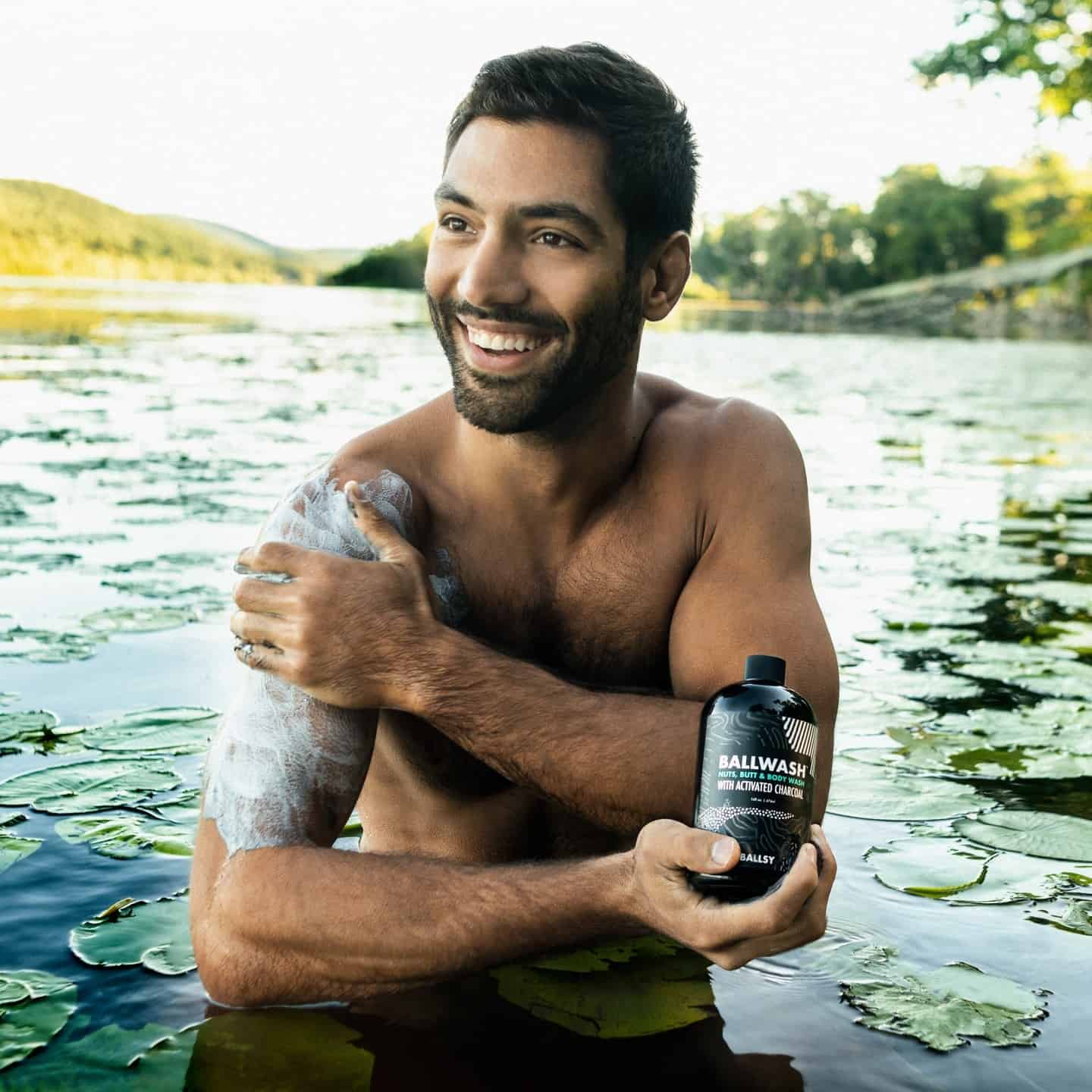man washing his arm in a lake