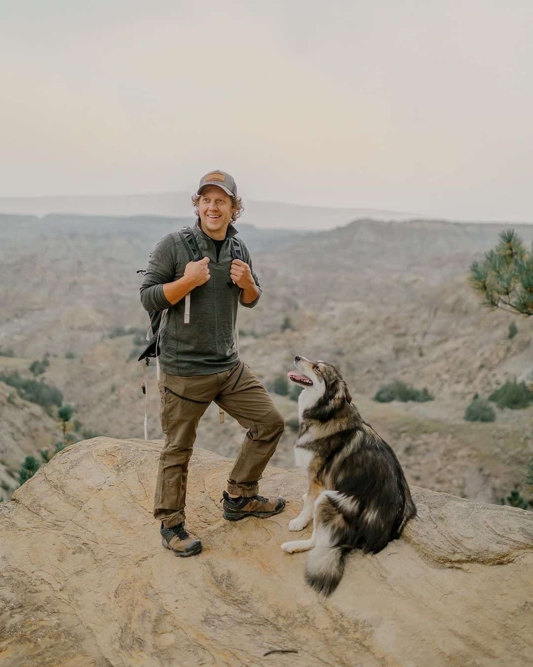 man and pet dog enjoying the mountains