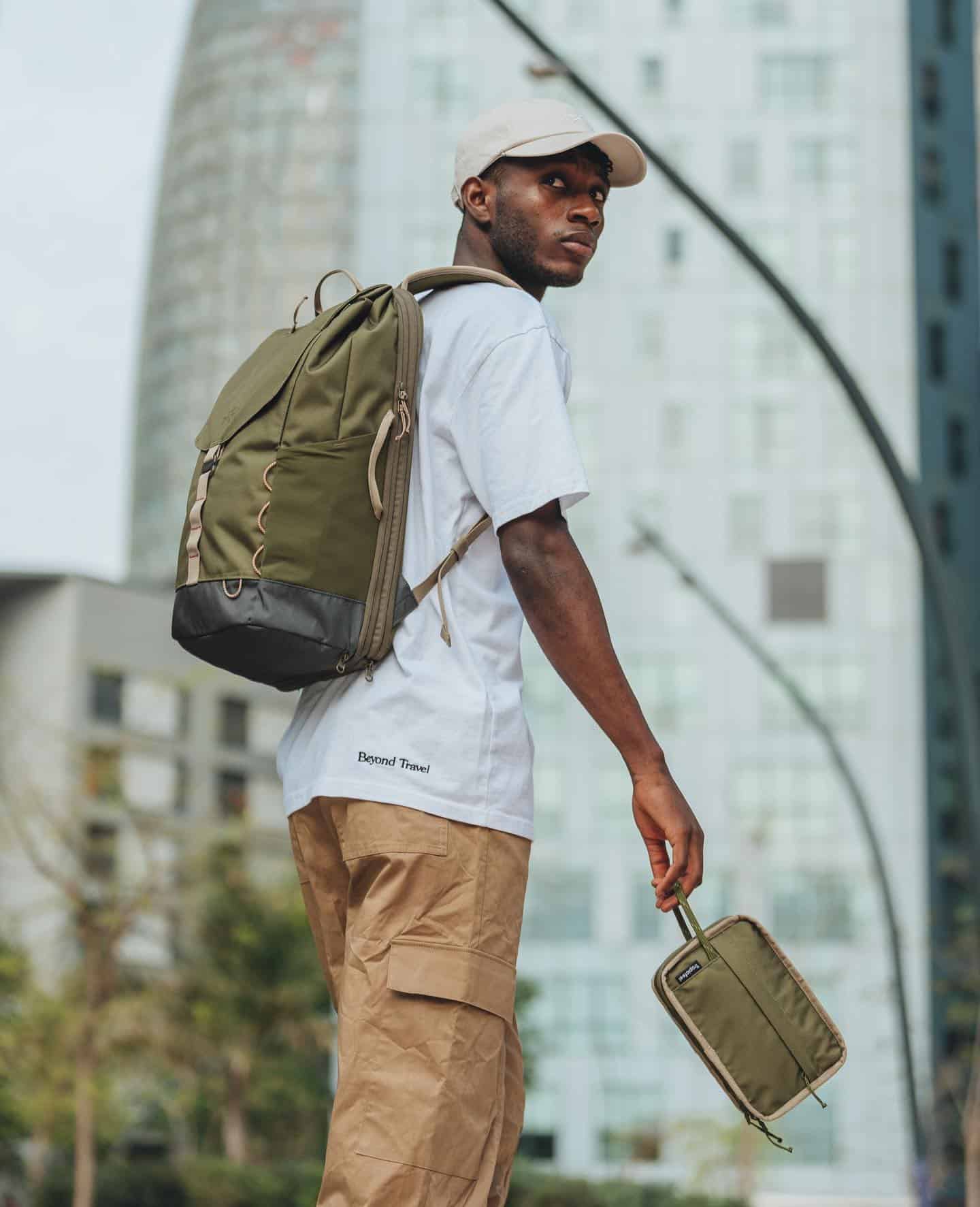 man carrying an olive green backpack
