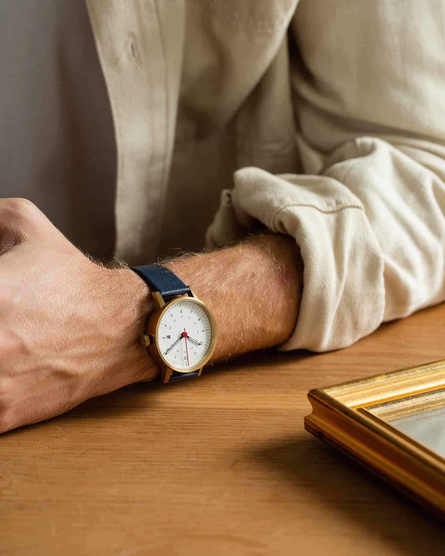 man wearing a watch with blue leather strap