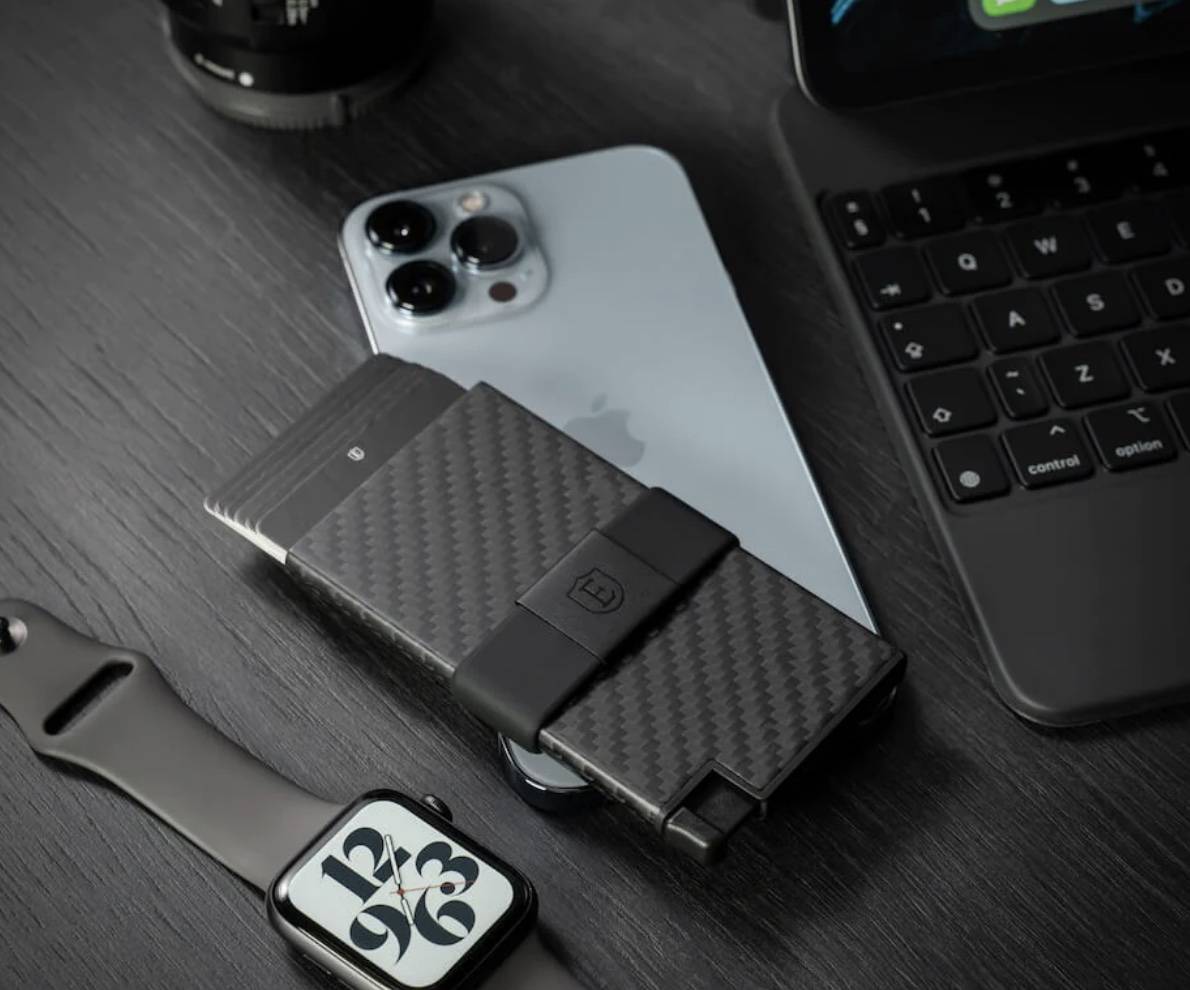 Ekster Carbon Fiber Wallet with iPhone, watch and laptop