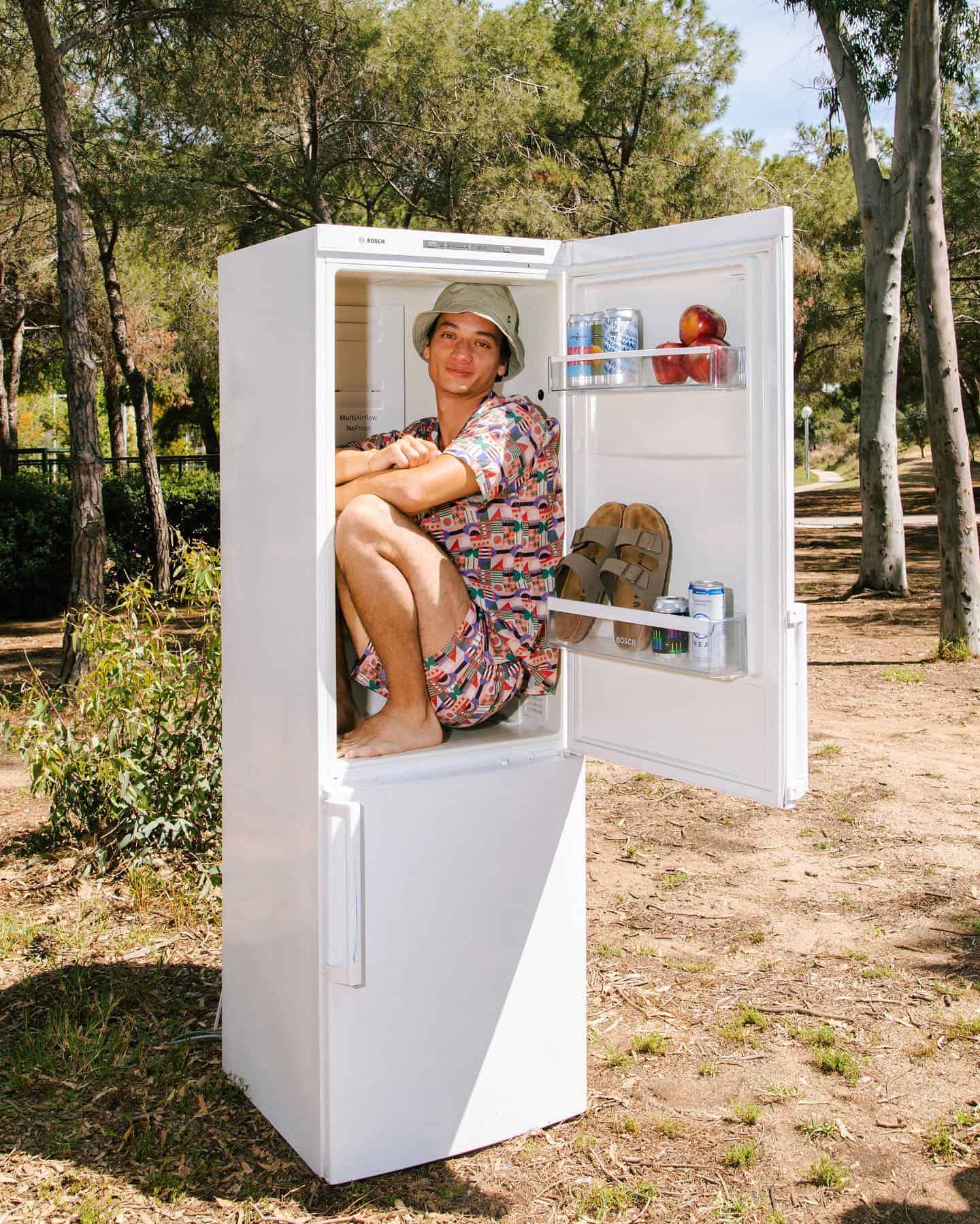 man sitting inside a fridge