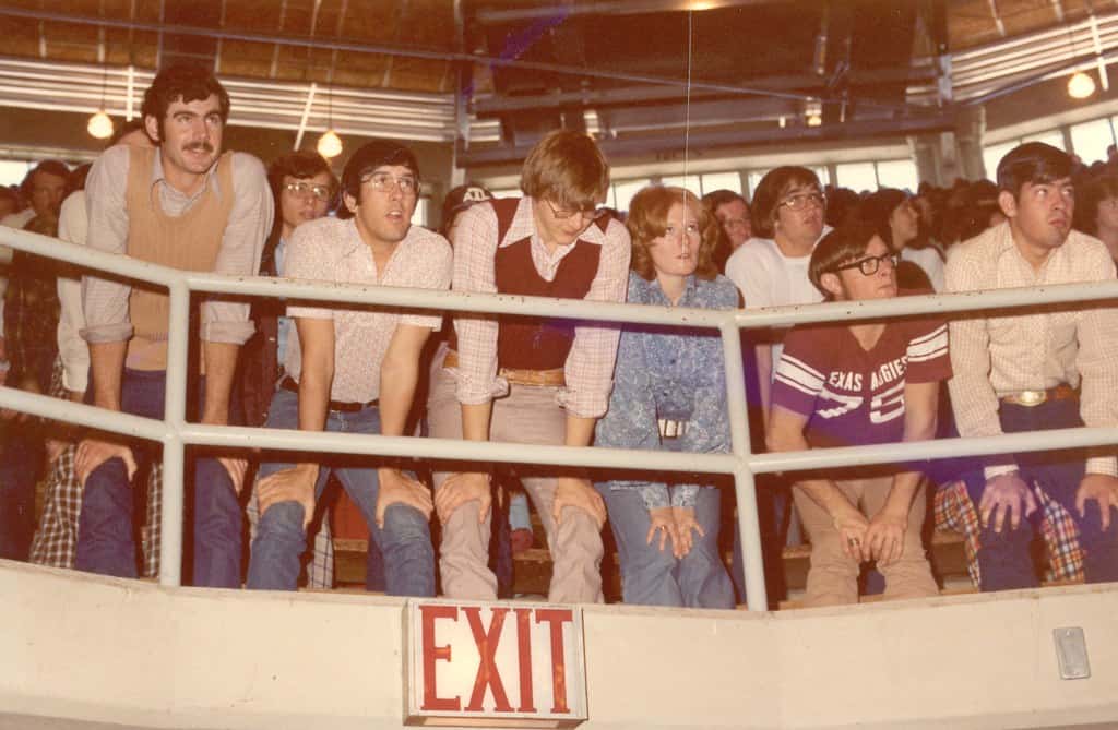group of people in 1980s watching basketball in a stadium