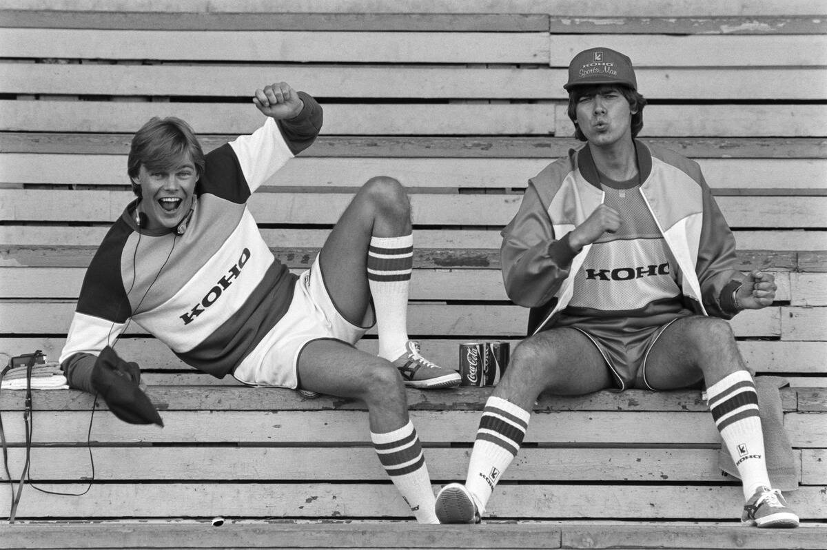 two men in 1980s cheering from the bleachers