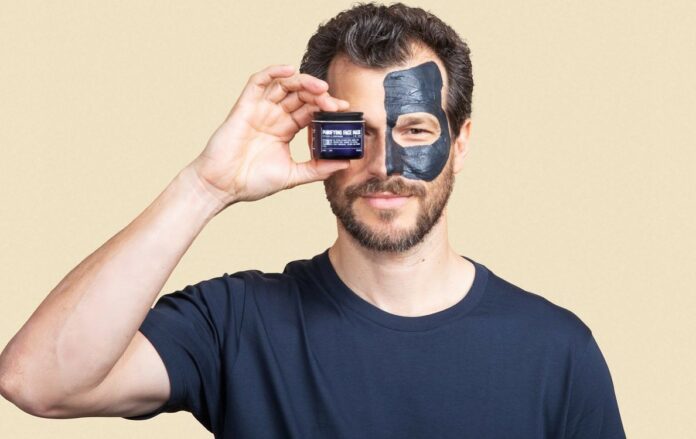 man holding a bottle of purifying face mask by blu atlas