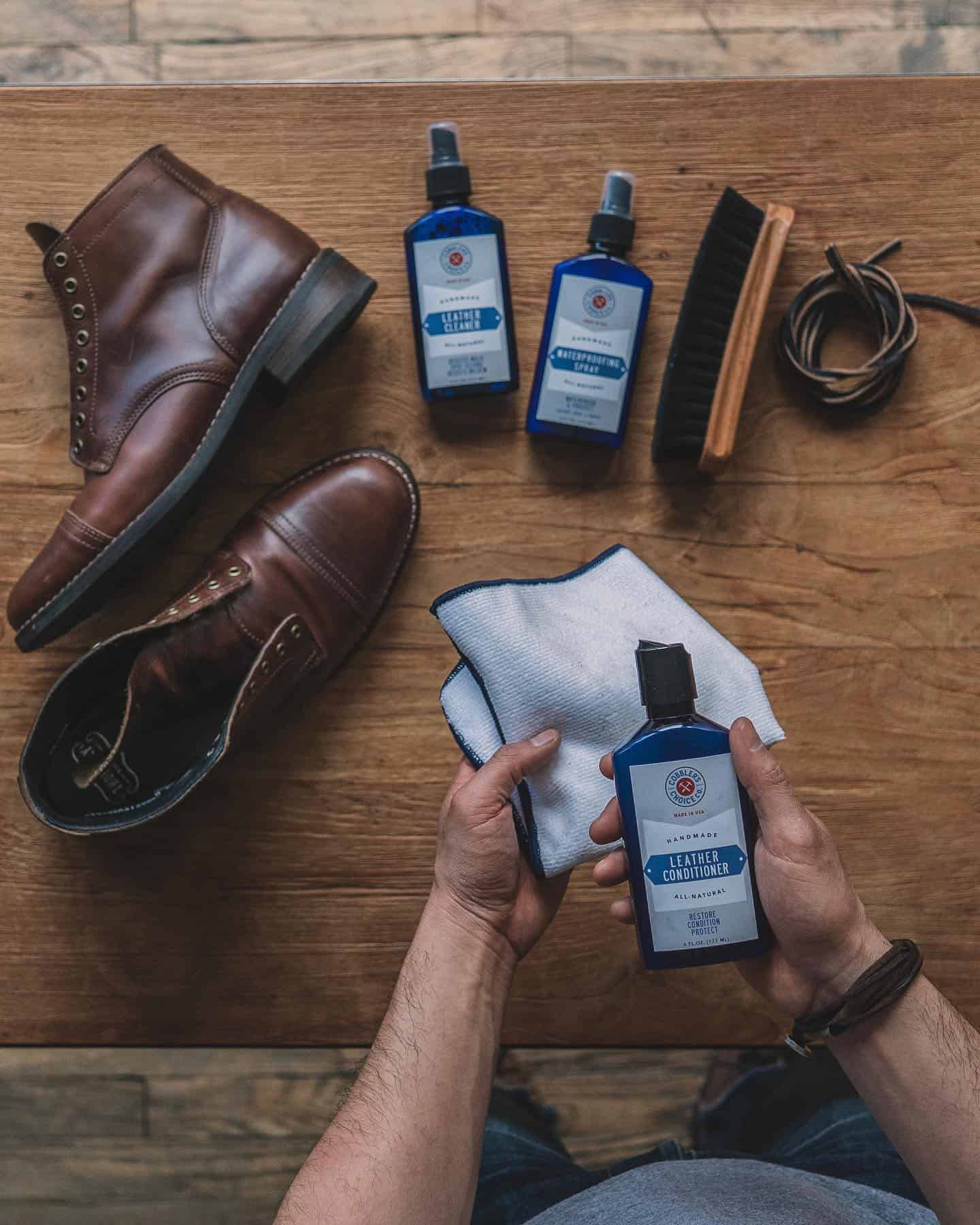 man holding a cloth and a bottle of leather conditioner by cobbler's choice