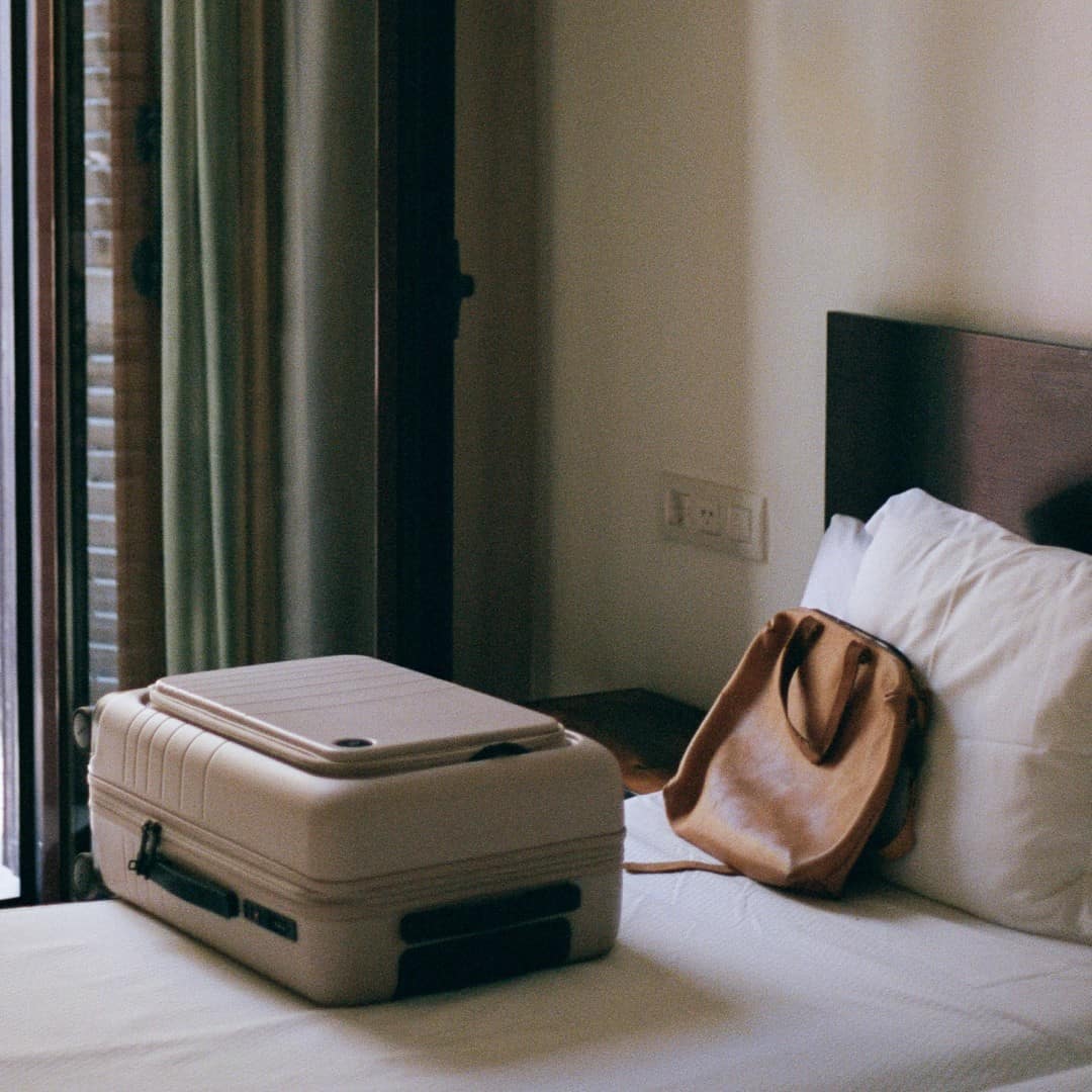 a monos luggage bag on the bed