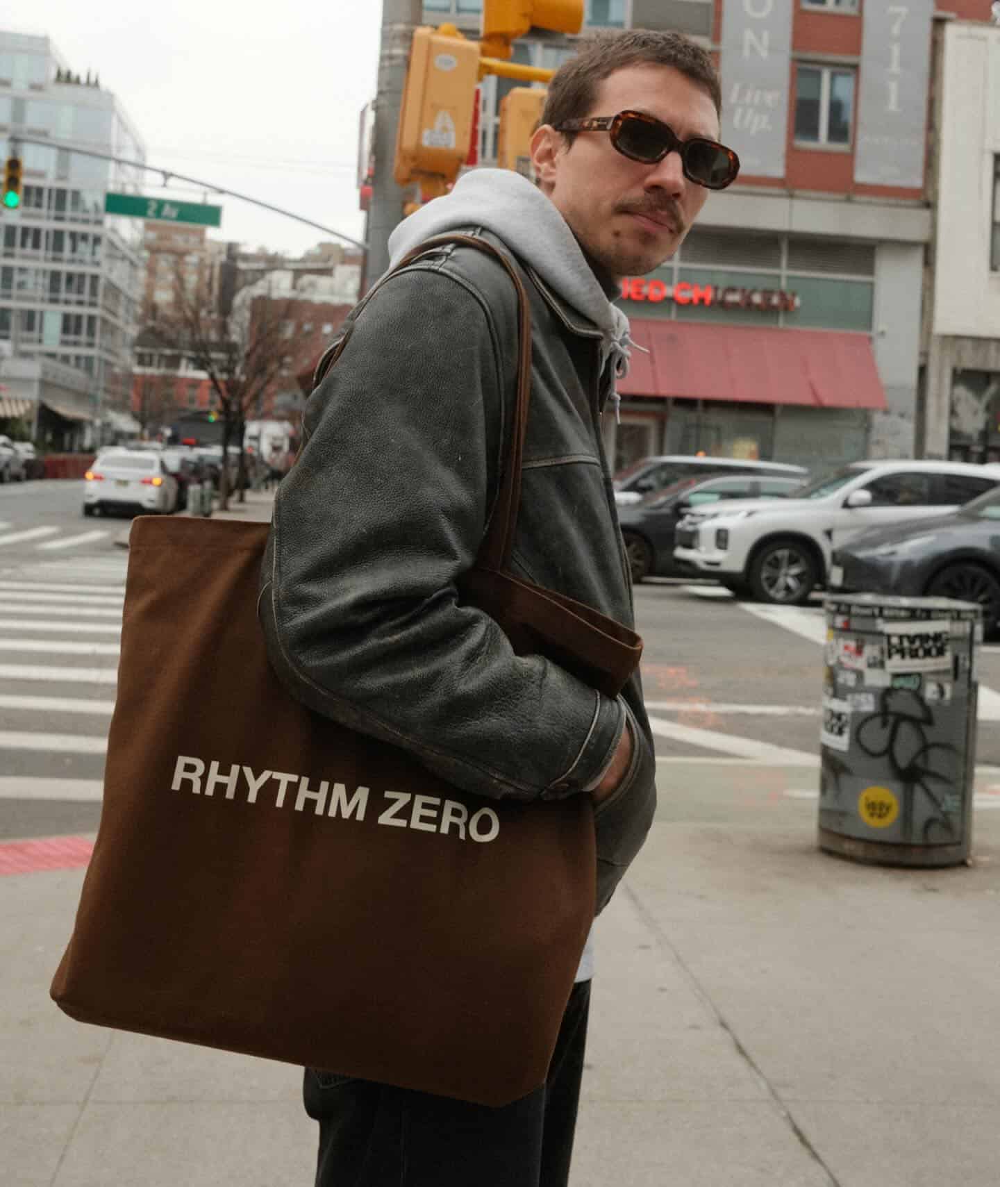 man with sunglasses carrying a tote bag on his shoulder
