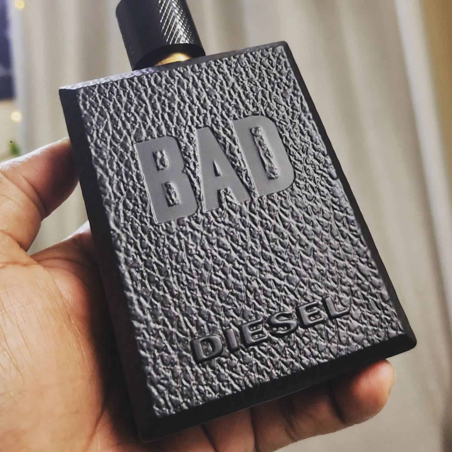 holding a bottle of the bad cologne by diesel
