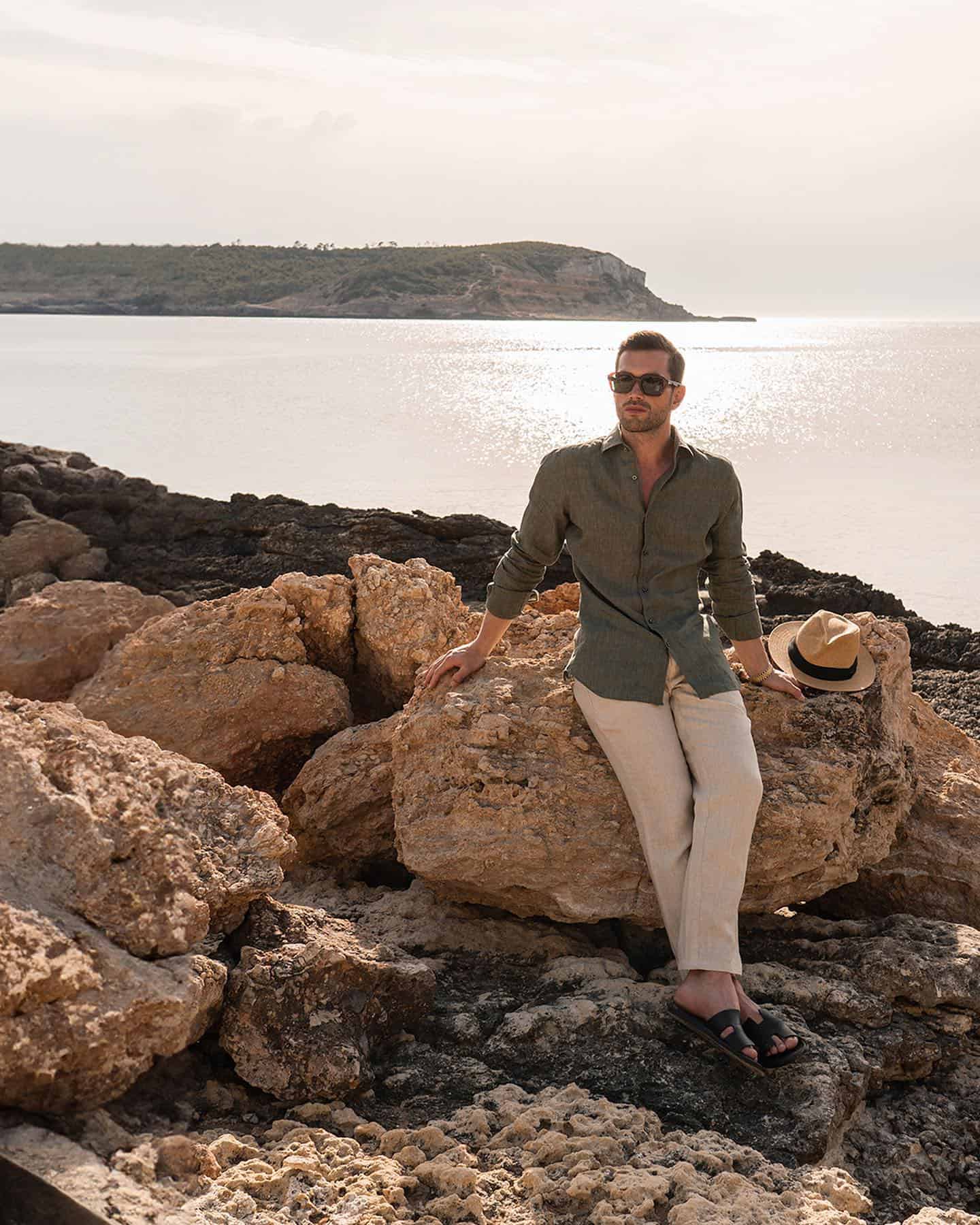 man sitting on a rock by the sea