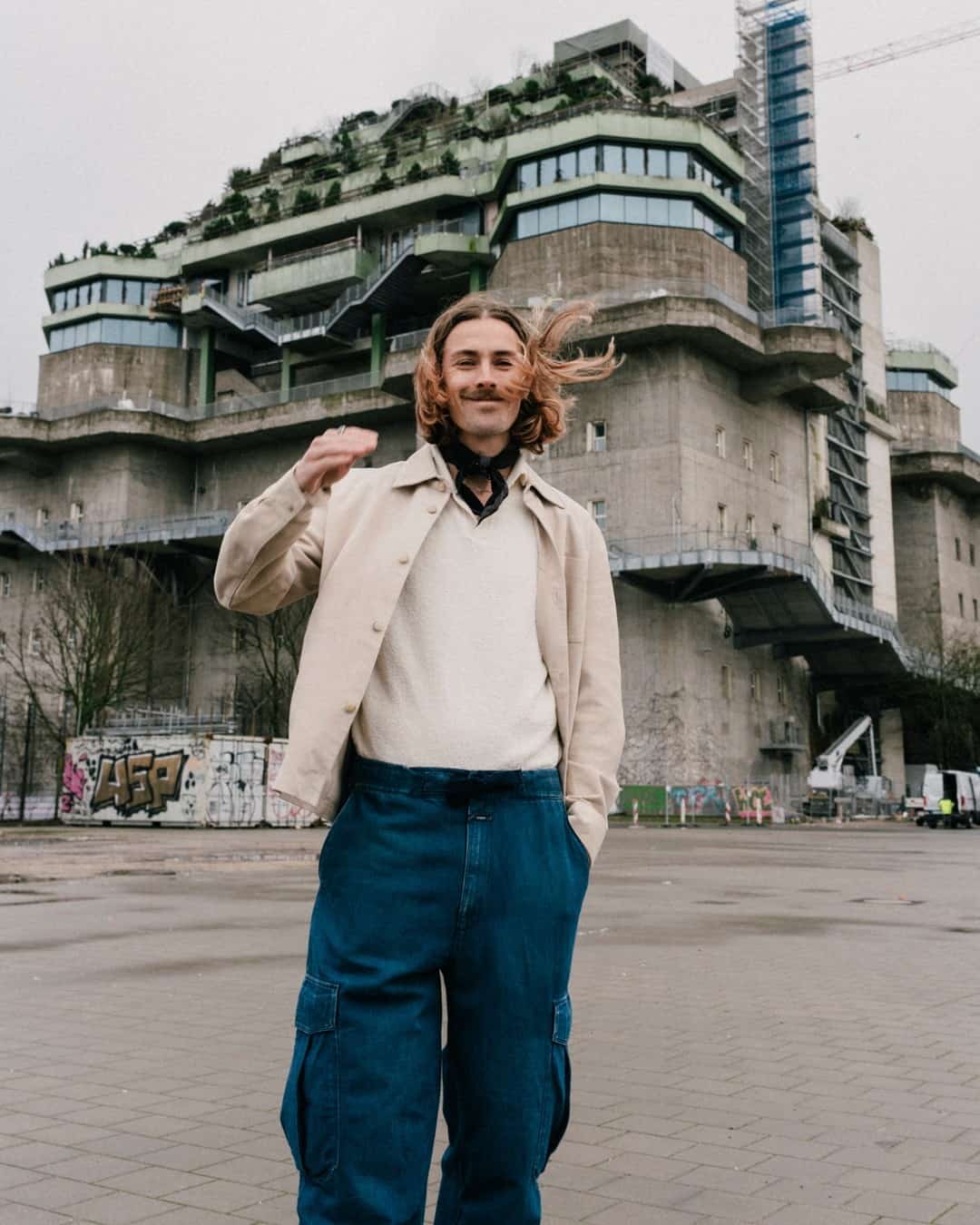 man in an off-white denim jacket and blue cargo pants