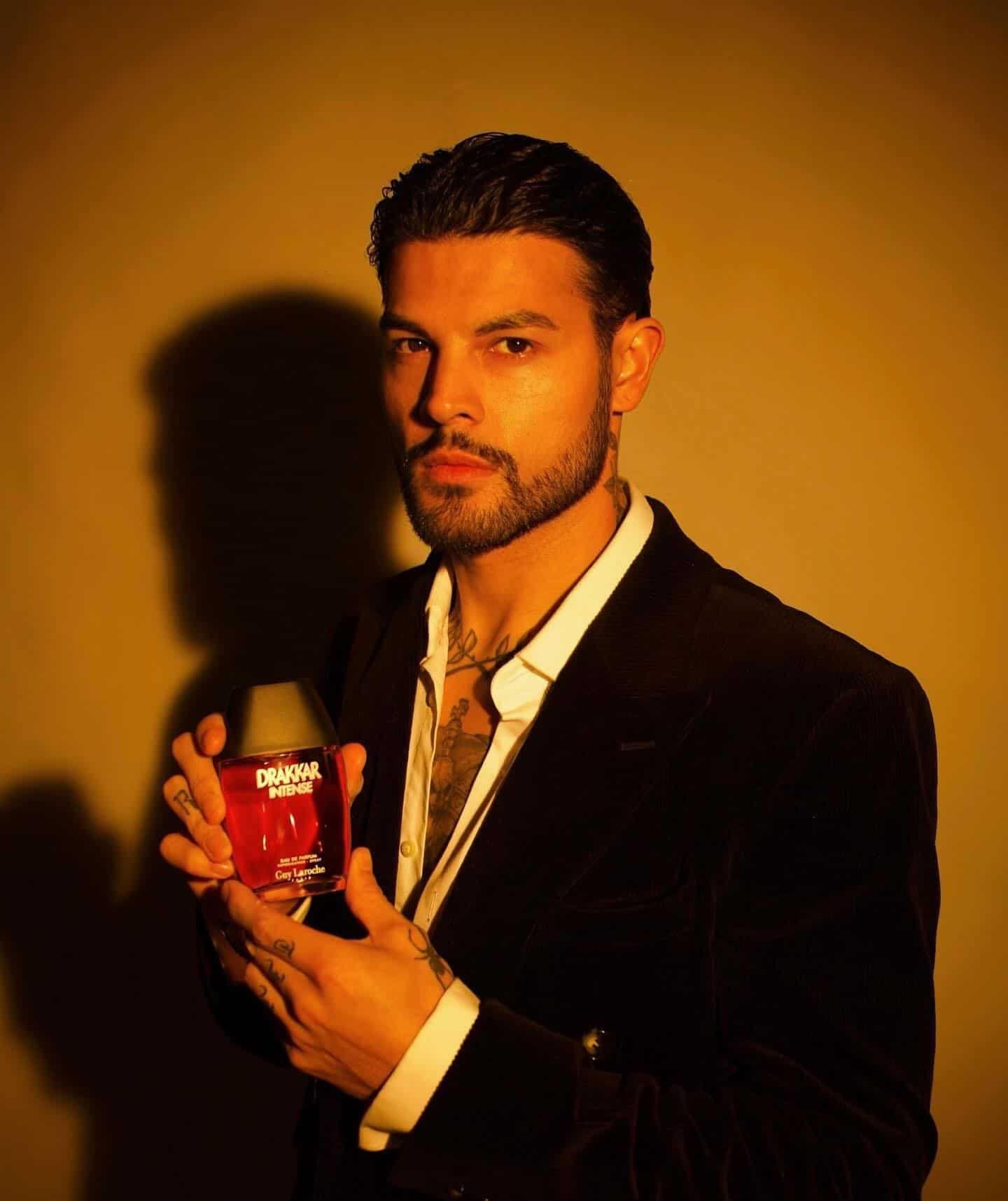 man holding a bottle of drakkar intense cologne