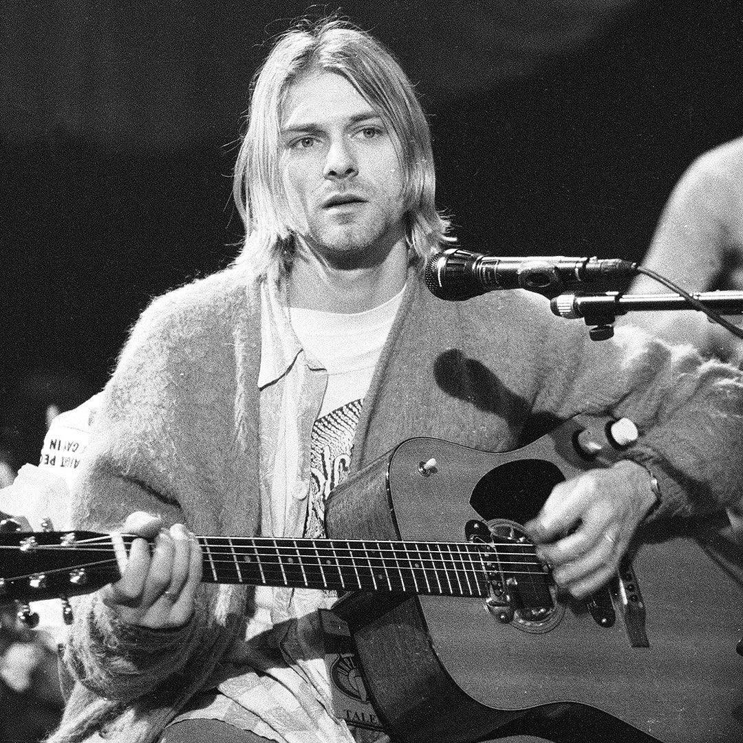 kurt cobain on the stage with a guitar