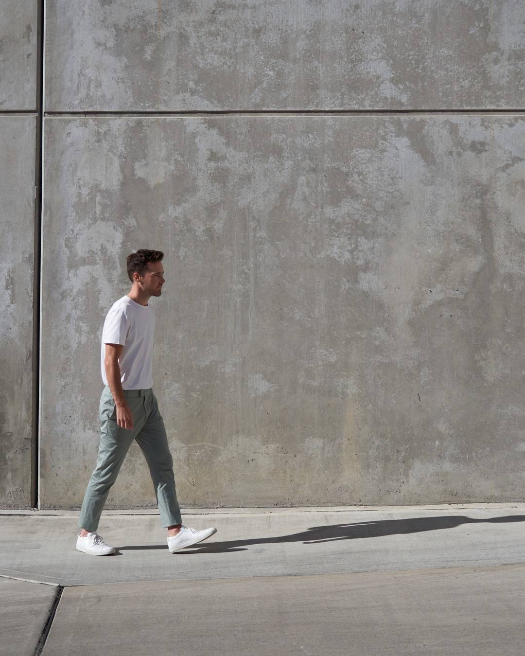 man wearing a sage trousers and white tee by l'estrange london
